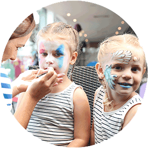 Two kids getting their faces painted