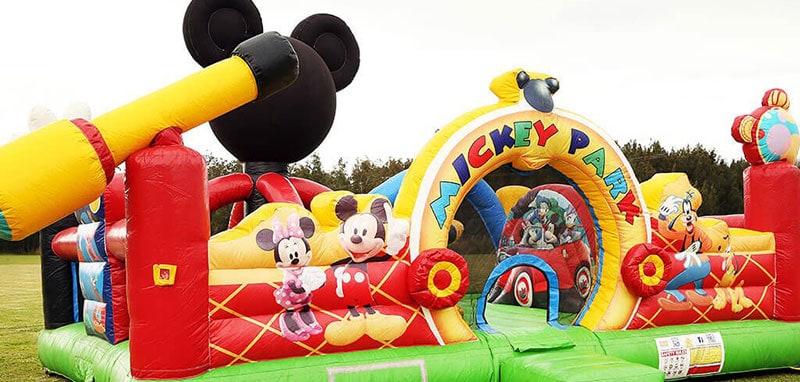 Colourful jumping castle with Mickey Mouse characters on it.
