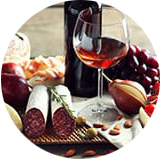 A shakuri board with meats, nut, fruits and wine.