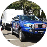 Blue four-wheeled drive utility truck towing a caravan at the Caravan Camping Expo.
